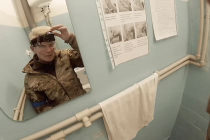 La médica Yuliia Paievska, conocida como Taira, se mira en el espejo y apaga su cámara en Mariúpol, Ucrania, el 27 de febrero del 2022. Usando su cámara corporal, Taira grabó los esfuerzos de su equipo para salvar las vidas de heridos en la asediada ciudad. Le entregó las desgarradoras imágenes a un equipo de la Associated Press. Soldados rusos capturaron a Taira y a su chofer el 16 de marzo. (Yuliia Paievska vía AP)