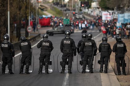 La policía bloquea el acceso en una carretera a las personas que marchan para exigir mejores salarios y empleos en Buenos Aires, Argentina, el viernes 18 de junio de 2021. (AP Foto/Víctor R. Caivano)