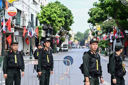 La policía vietnamita hace guardia en una calle de Hanoi a la espera del presidente ruso Vladimir Putin. (Photo by Nhac NGUYEN / AFP)