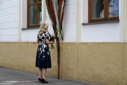 La primera dama de Estados Unidos Jill Biden pausa antes de colocar flores en un memorial en Bratislava, Eslovaquia, el 7 de may del 2022, que está dedicado al periodista investigador Jan Kuciak y su prometida Martina Kusnirova, asesinados en su casa en el 2018. (AP Foto/Susan Walsh, Pool)