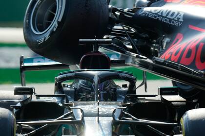 La rueda Red Bull de Max Verstappen sobre el Mercedes de Lewis Hamilton durante el Gran Premio de Italia, el domingo 12 de septiembre de 2021, en Monza. (AP Foto/Luca Bruno)
