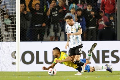 Lionel Messi deja en el suelo a Matheus Cunha, en una acción que terminará confusa; la Argentina empató con Brasil en San Juan por la eliminatoria para el Mundial Qatar 2022 y concluyó un muy buen año, sobre todo, para el capitán.