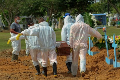 Los sepultureros llevan el ataúd de una víctima de Covid-19 en el cementerio de Nossa Senhora Aparecida en Manaos, estado de Amazonas, Brasil, el 22 de enero de 2021, en medio de la pandemia del nuevo coronavirus