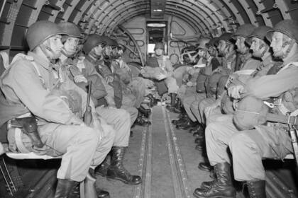 Paracaidistas estadounidenses, fuertemente armados, sentados dentro de un avión militar mientras sobrevuelan el Canal de la Mancha en ruta hacia la costa francesa de Normandía para la invasión aliada del Día D del bastión alemán durante la Segunda Guerra Mundial, el 6 de junio de 1944