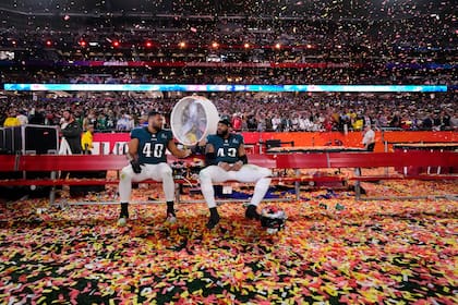 Patrick Johnson (48) y Kyzir White (43), linebackers de los Eagles de Filadelfia, están en la banca después de su derrota en el Super Bowl 57, el domingo 12 de febrero de 2023, en Glendale, Arizona. Los Chiefs derrotaron a los Eagles 38-35. (AP Foto/Matt Slocum)