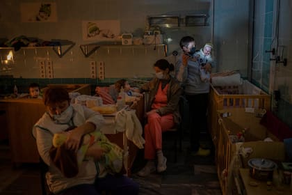 Personal atiende a niños huérfanos en el pabellón de maternidad del hospital regional infantil, el martes 22 de noviembre de 2022, en Jersón, en el sur de Ucrania. (AP Foto/Bernat Armangue)