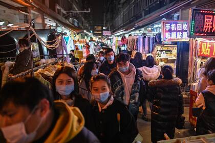 Personas con tapabocas caminan por un mercado en Wuhan, provincia central de Hubei en China, el 5 de febrero de 2021