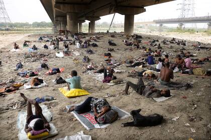 Personas sin casa duermen a la sombra de un puente el viernes 20 de mayo de 2022 para refrescarse del calor que azota Nueva Delhi, India. (AP Foto/Manish Swarup, archivo)