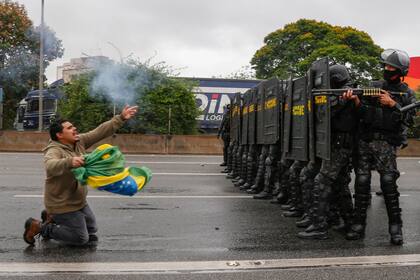 Policías antidisturbios toman posición para despejar un bloqueo realizado por partidarios del presidente Jair Bolsonaro en la carretera de Castelo Branco, en las afueras de San Pablo, Brasil, el 2 de noviembre de 2022