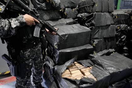 Policías custodian droga incautada en varios operativos policiales para ser incinerada en Cayambe, Ecuador, el jueves 21 de abril de 2022. (Foto AP/Dolores Ochoa)