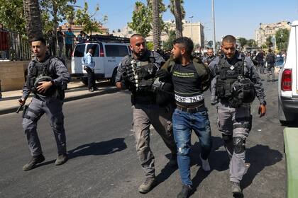 Policías israelíes detinenen a un hombre palestino durante enfrentamientos fuera de la Ciudad Vieja de Jerusalén, el martes 15 de junio de 2021, previos a una planeada marcha de ultranacionalistas judíos a través de Jerusalén oriental. (AP Foto/Mahmoud Illean)