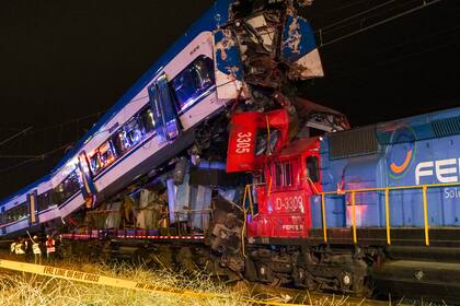 Policías y bomberos inspeccionan dos trenes que colisionaron en San bernardo, Santiago de Chile, el jueves 20 de junio de 2024. (AP Foto/Alexandre Plaza)