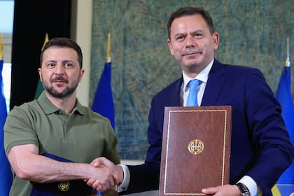 El primer ministro portugués, Luís Montenegro, y el presidente de Ucrania, Volodimir Zelensky, se dan la mano después de firmar acuerdos en el Palacio de Sao Bento en Lisboa