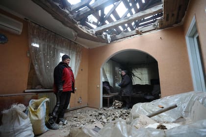 Residentes de Stanytsia Luganska, en la región ucraniana prorrusa de Lugansk, evalúan daños tras una explosión (Photo by Aleksey Filippov / AFP)