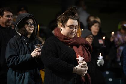 Residentes del condado Warren encienden velas en honor de las víctimas de los recientes tornados, en una vigilia en el Bowling Green Ballpark el lunes 20 de diciembre de 2021, en Bowling Green, Kentucky. (Grace Ramey/Daily News vía AP)