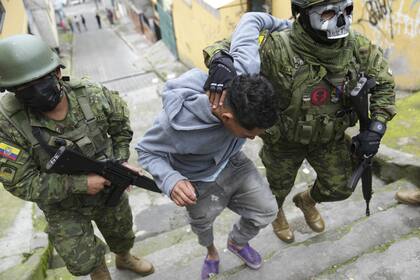 Soldados detienen a un joven en las calles de Quito, Ecuador. (AP/Dolores Ochoa)