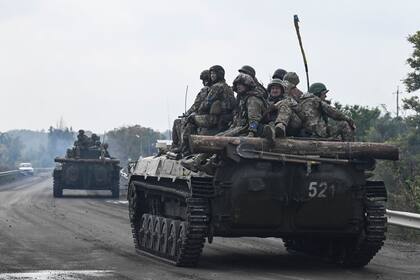 Soldados ucranianos sentados en vehículos de combate de infantería mientras conducen cerca de Izyum, en el este de Ucrania, el 16 de septiembre de 2022, en medio de la invasión rusa de Ucrania.