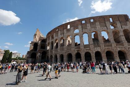 Turistas caminan cerca del Coliseo en Roma, Italia