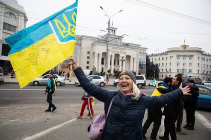 Ucranianos reunidos en el centro para celebrar que tropas ucranianas han recuperado su ciudad, Jersón, en Ucrania, el sábado 12 de noviembre de 2022. (AP Foto/Yevhenii Zavhorodnii)