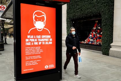Un cartel en Londres que advierte sobre multas para quienes usen el transporte público sin tapabocas