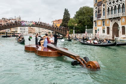 Un cuarteto de cuerdas toca  "Cuatro estaciones", de Vivaldi, sobre una embarcación con forma de violín en el Gran Canal de Venecia, Italia