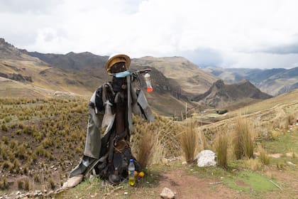 Un espantapájaros disfrazado de minero se encuentra cerca de la oficina abandonada de una mina que cerró en algún momento de las últimas décadas del siglo XX en el pueblo fantasma de Santa Bárbara, Perú, el jueves 2 de diciembre de 2021. (AP Foto/Franklin Briceño)