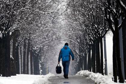 Un hombre camina por una calle cubierta de nieve en Belgrado, Serbia, el domingo 26 de febrero de 2023. (AP Foto/Darko Vojinovic)
