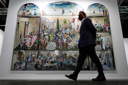 Un hombre recorre el predio de IFEMA durante ARCO 2021; detrás, una obra del artista español Gino Rubert