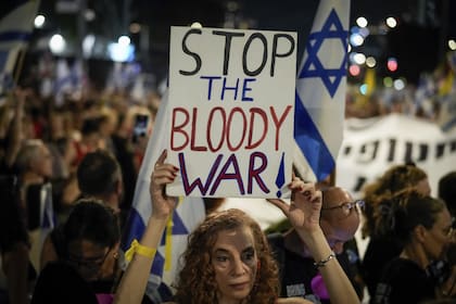 Un manifestante sostiene un cartel que dice "paren la sangrienta guerra" durante una protesta que conmemora los nueve meses desde el inicio de la guerra y pide la liberación de los rehenes retenidos en la Franja de Gaza por el grupo militante Hamas, en Tel Aviv, Israel, el domingo 7 de julio de 2024.