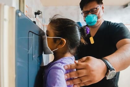 Un médico realiza una radiografía a una niña en la clínica TB Móvil de la ONG Socios en Salud en Perú