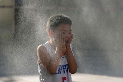 Un niño trata de evitar el calor en Beijing, el 15 de junio del 2024. (AP Foto/Ng Han Guan)