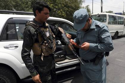 Un policía afgano revisa los documentos de un ciudadano en Kabul el 4 de julio del 2021. (Foto AP/Rahmat Gul)