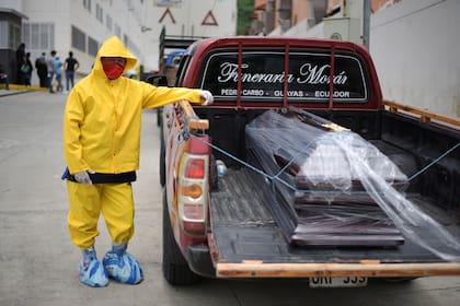 Un trabajador de una funeraria transporta un féretro en Los Ceibos, Ecuador