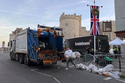 Un trabajador se deshace de bolsas de basura, tras el funeral de estado de la reina Isabel II, en Windsor, Inglaterra, el martes 20 de septiembre