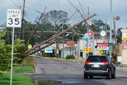 Una calle con postes caídos tras el paso del huracán Ida, en Merairea, Luisiana, el 30 de agosto de 2021. (AP Foto/Steve Helber)