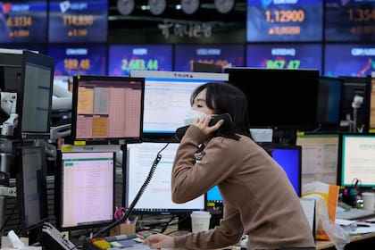 Una corredora de divisas habla por teléfono en la sede del KEB Hana Bank, el jueves 24 de febrero de 2022, en Seúl, Corea del Sur. (AP Foto/Ahn Young-joon)