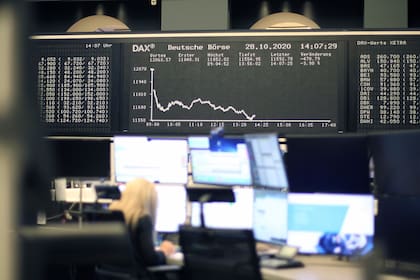 Una corredora se sienta debajo de la pantalla que muestra la evolución del índice bursátil alemán DAX en la bolsa de valores de Frankfurt, Alemania, el 28 de octubre de 2019, en medio de la pandemia de coronavirus