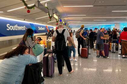 Una empleada de Southwest Airlines revisa equipaje no reclamado y reenviado el martes 27 de diciembre de 2022 en el Aeropuerto Internacional Fort Lauderdale-Hollywood en Fort Lauderdale, Florida. (Joe Cavaretta/South Florida Sun-Sentinel vía AP)