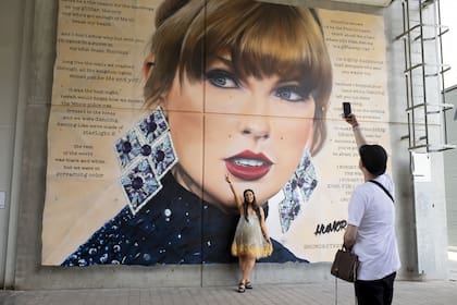 Una fan posa delante de un mural de Taylor Swift en el estadio de Wembley antes de su primer concierto en Londres, durante la gira Eras Tour, en Londres, el viernes 21 de junio de 2024.