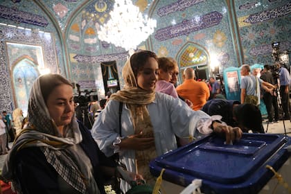Una mujer coloca su sufragio en la urna en el centro de votación de Hosseiniyeh Ershad en el norte de Teheran. Photo: Rouzbeh Fouladi/ZUMA Press Wire/dpa