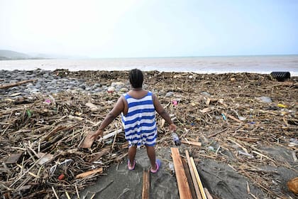 Una mujer mira una playa llena de basura en Bull Bay, Jamaica, tras el paso del huracán Beryl, el 4 de julio de 2024