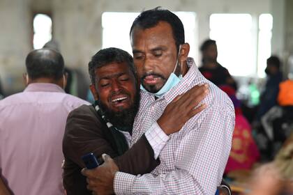 Una persona consuela a un familiar que no logra encontrar a su hijo de cinco años, que viajaba en un transbordador que se incendió, en un hospital del gobierno en Barishal, Bangladesh, el viernes 24 de diciembre de 2021. (AP Foto/Niamul Rifat)