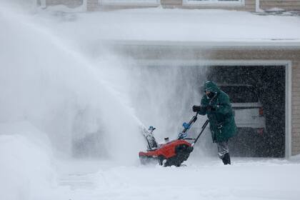 Una vecina retira nieve de la puerta de su domicilio en Des Moines, Iowa. (JOE RAEDLE / GETTY IMAGES NORTH AMERICA / Getty Images via AFP)