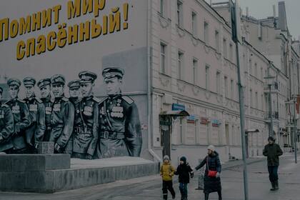 Unos peatones pasan junto a un mural patriótico dedicado a la victoria en la Segunda Guerra Mundial, en Moscú, el 17 de febrero de 2023.