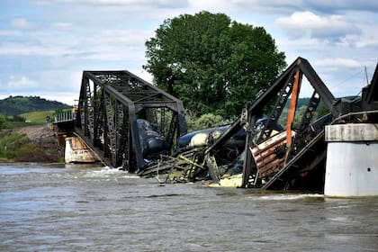 Varios vagones de un tren de carga están semisumergidos en el río Yellowstone tras el derrumbe de un puente cerca de Columbus, Montana, sábado 24 de junio de 2023